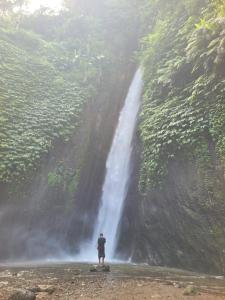 a man standing in front of a waterfall at The Sinta Bali in Munduk +5 photos