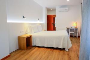 ein Schlafzimmer mit einem weißen Bett und einem Holzboden in der Unterkunft Hotel Flor do Minho in Valença + 58 Fotos