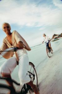 two men riding bikes on the beach at Nômade Temple Holbox in Holbox Island
