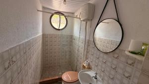 a bathroom with a sink and a toilet and a mirror at Suítes Recanto dos papagaios in Angra dos Reis +25 photos