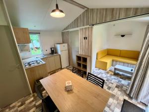 a kitchen and dining room with a table and a couch at Camping le Martin Pêcheur in Magné