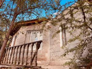 a stone building with a window and a stone column at Hospedaje San Luis Sierras in Juana Koslay 