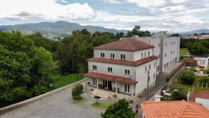 ein großes weißes Gebäude mit rotem Dach in der Unterkunft Hotel Flor do Minho in Valença