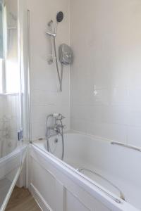a white bathroom with a tub and a shower at Fordel Cottage in Dalkeith +7 photos