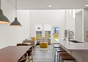 a kitchen and living room with a table and a couch at Modern Townhouse with Pool Gym & Tennis Near Beach in Ocean View