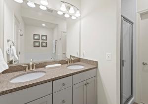a bathroom with two sinks and a large mirror at Modern Townhouse with Pool Gym & Tennis Near Beach in Ocean View +25 photos