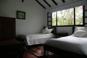 a bedroom with two beds and a window at Finca Villa Sofía in Villa de Leyva