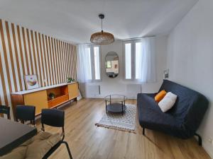 a living room with a couch and a table at Hyper centre Libourne - Cosy & tout à pied in Libourne
