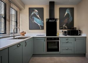 a kitchen with a sink and two birds on the wall at Whistler Rooms in Peterborough +7 photos