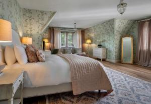 a bedroom with a large bed and green wallpaper at Whistler Rooms in Peterborough