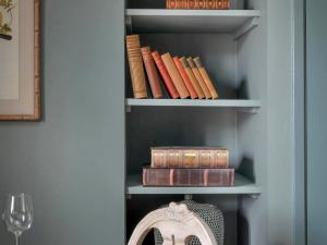 a book shelf filled with books next to a wine glass at Whistler Rooms in Peterborough