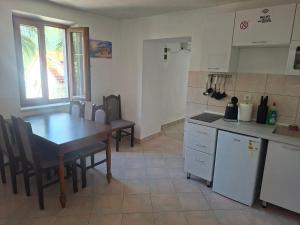 a kitchen with a wooden table and a table and a table and chairs at Apartman Perast in Perast