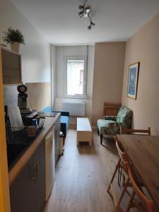 a kitchen and a living room with a table at Le Nid Didier in Saint-Didier-en-Velay