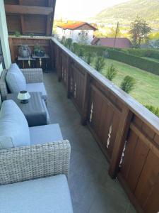 a balcony with couches and a view of a yard at Ferienwohnungen Tarmann in Bodensdorf