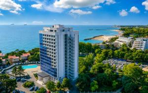 an aerial view of a tall building next to the ocean at Olimp Sea View Apartments by Maritimo in Olimp