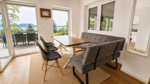 a dining room with a table and chairs and windows at Hilltop Apartments in Fonyód