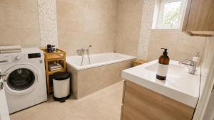 a bathroom with a washing machine and a sink at Hilltop Apartments in Fonyód +33 photos