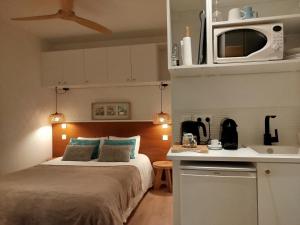 a small bedroom with a bed and a kitchen at Studio à la VILLA VOLTAIRE in Clamart