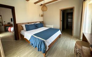 a bedroom with a large bed with blue pillows at Mathilda Gökçeada in Gokceada Town