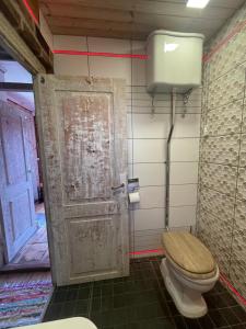 a bathroom with a toilet and an open door at Posti Tiny House with Garden in Haapsalu +12 photos