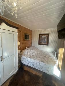 a bedroom with a bed and a chandelier at Posti Tiny House with Garden in Haapsalu
