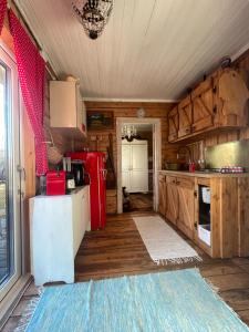 a kitchen with a red refrigerator and wooden cabinets at Posti Tiny House with Garden in Haapsalu