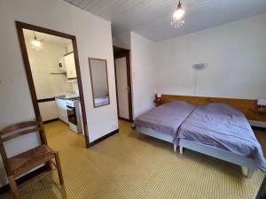 a bedroom with a bed and a small kitchen at MF n 8 in Cazaubon
