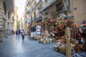 a woman walking down a street with a store at Balcón de Manet in Valencia