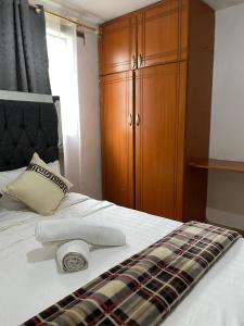 a bedroom with a bed with two towels and a cabinet at Suki Ruaka Homes in Ruaka