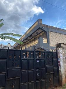 a black garage door with a building behind it at Suki Ruaka Homes in Ruaka
