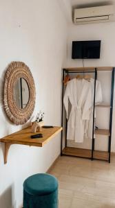 a room with a mirror and a shelf with a shirt at Anthoula House Sarti in Sarti