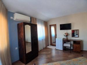 a room with a mirror and a desk and a television at Zenith Guest House in Sozopol +90 photos