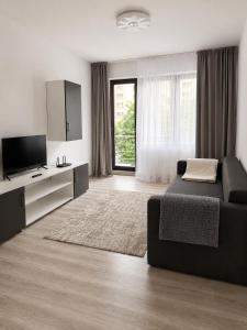 a living room with a couch and a flat screen tv at Nolia Apartments in Bucharest