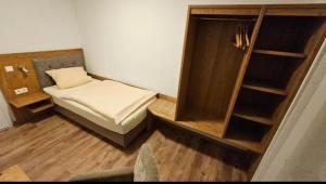 a small room with a small bed and shelves at Herr Berge in Fritzlar