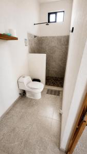 a bathroom with a toilet and a shower at Casa Arena, Zipolite Playa del Amor in Zipolite