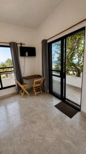 a living room with large windows and a table and chairs at Casa Arena, Zipolite Playa del Amor in Zipolite +2 photos