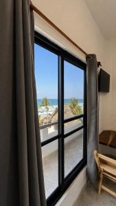 a room with a window with a view of the beach at Casa Arena, Zipolite Playa del Amor in Zipolite