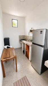 a kitchen with a refrigerator and a wooden table at Casa Arena, Zipolite Playa del Amor in Zipolite