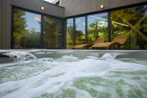 a jacuzzi tub filled with water in a building at Chalets Szőcs-birtok in Izvoare