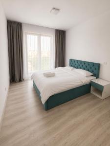 a bedroom with a large bed and a large window at Nolia Apartments in Bucharest