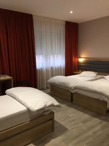 a hotel room with two beds and a window at Auberge La Veranda in Luxembourg