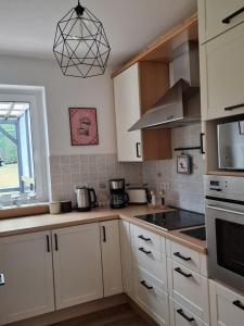 a kitchen with white cabinets and a stove top oven at Waldpanorama Schildberg in Lügde +7 photos