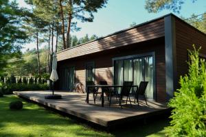 a cabin with a table and chairs on a deck at Grace Place in Soshnikov