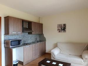 a small kitchen with a couch and a microwave at Cor De Prades in Mont-ral