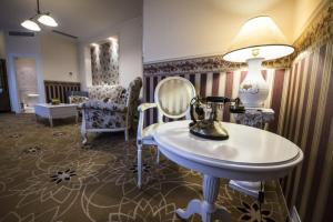a room with a table and a lamp and chairs at Golden Royal Boutique Hotel & Spa in Košice