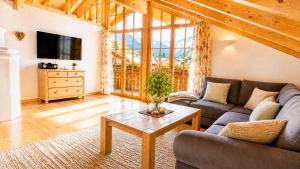 a living room with a couch and a table at AlpStern Ferienwohnungen Oberstdorf in Oberstdorf