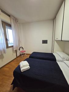 a bedroom with two beds and a red chair at Appartamento Polidea in Reggio di Calabria