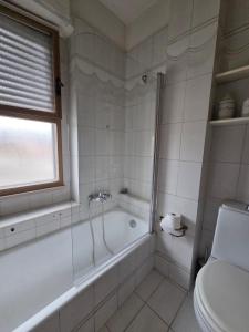 a white bathroom with a tub and a toilet at Appartamento Polidea in Reggio di Calabria +15 photos