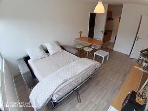 a bedroom with a bed and a table in it at Les Marines du Cachalot in Villers-sur-Mer