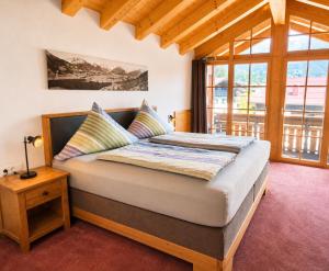 a large bed in a room with a large window at AlpStern Ferienwohnungen Oberstdorf in Oberstdorf +16 photos
